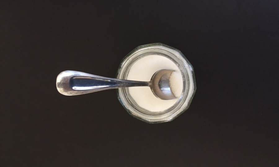 the image shows a sugar jar and spoon illustrates a blog article on sugar