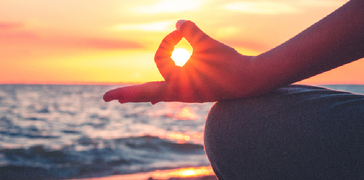 Seeting sun seen through a yoga hand mudra
